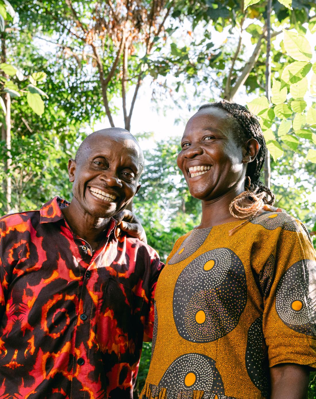 A couple smiling together among the trees they tend